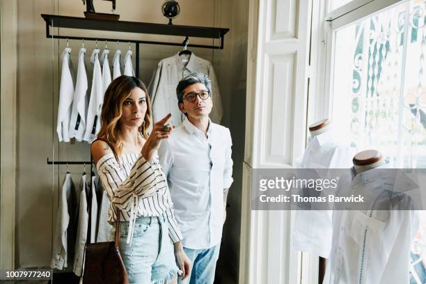 wife and husband shopping together in mens boutique - couple lifestyle jean stock pictures, royalty-free photos & images