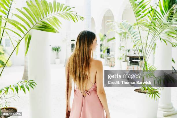 woman standing in courtyard of luxury shopping boutique - three quarter length stock pictures, royalty-free photos & images