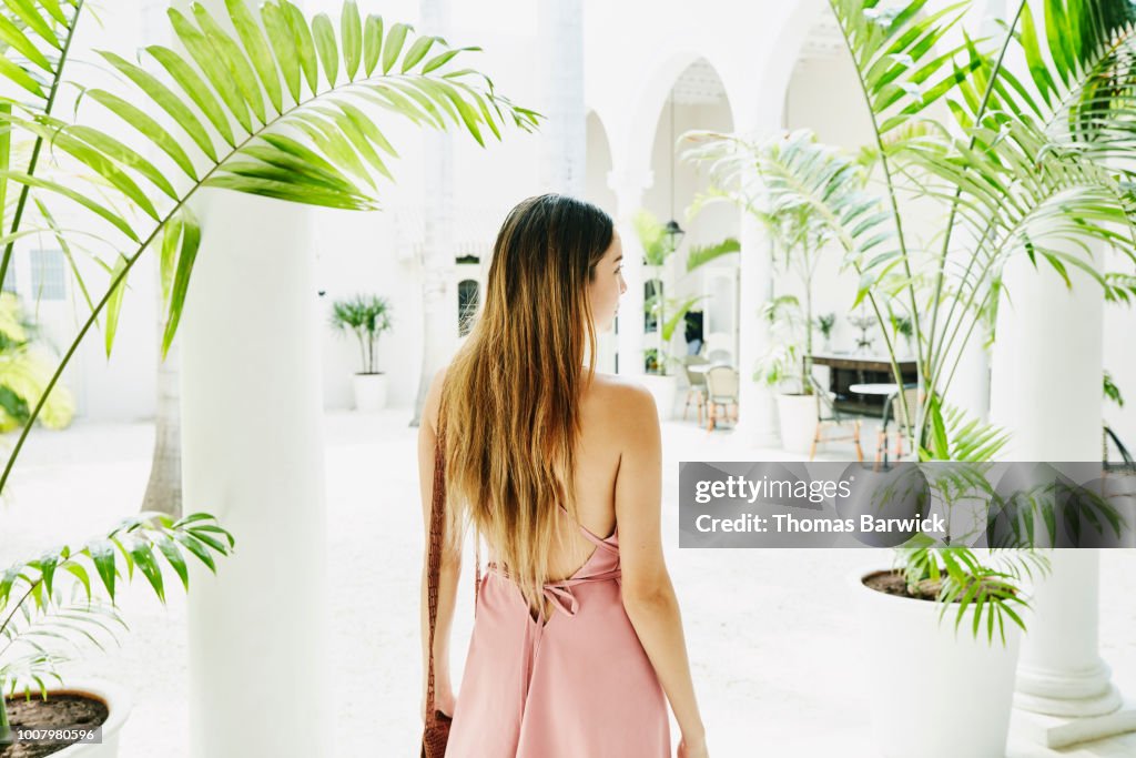 Woman standing in courtyard of luxury shopping boutique