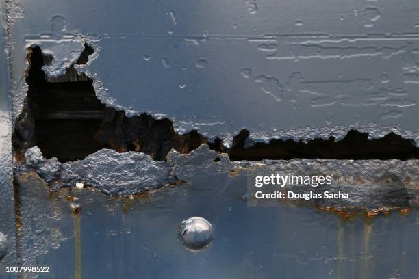 decaying rust hole in a metal plate - rusty stock pictures, royalty-free photos & images