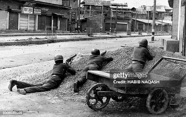 This photograph taken in 1989 shows Indian policemen taking positions after Kashmiri militants opened fire on government forces in the old city area...