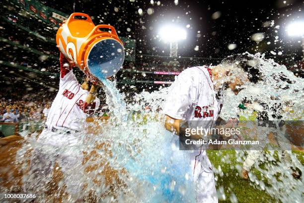 Blake Swihart is doused in Gatorade by Mookie Betts of the Boston Red Sox after hitting the game-winning walk-off ground-rule double in the...