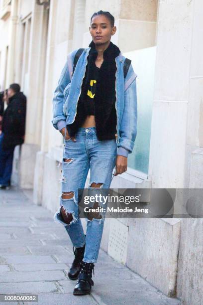 Model Ysaunny Brito exits the Balmain show in a denim jacket, distressed blue jeans, and black boots during Paris Fashion Week Fall/Winter 2017 on...