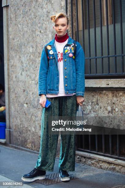 Model Lily Nova wears a denim jacket with pins, green felt pants, and black boots during Milan Fashion Week Fall/Winter 2017/18 on February 25, 2017...