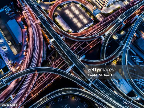 aerial view of busy intersection in twilight - overpass stockfoto's en -beelden