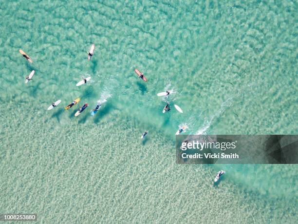 crystal clear waters with surfers seen from above - australia stock-fotos und bilder