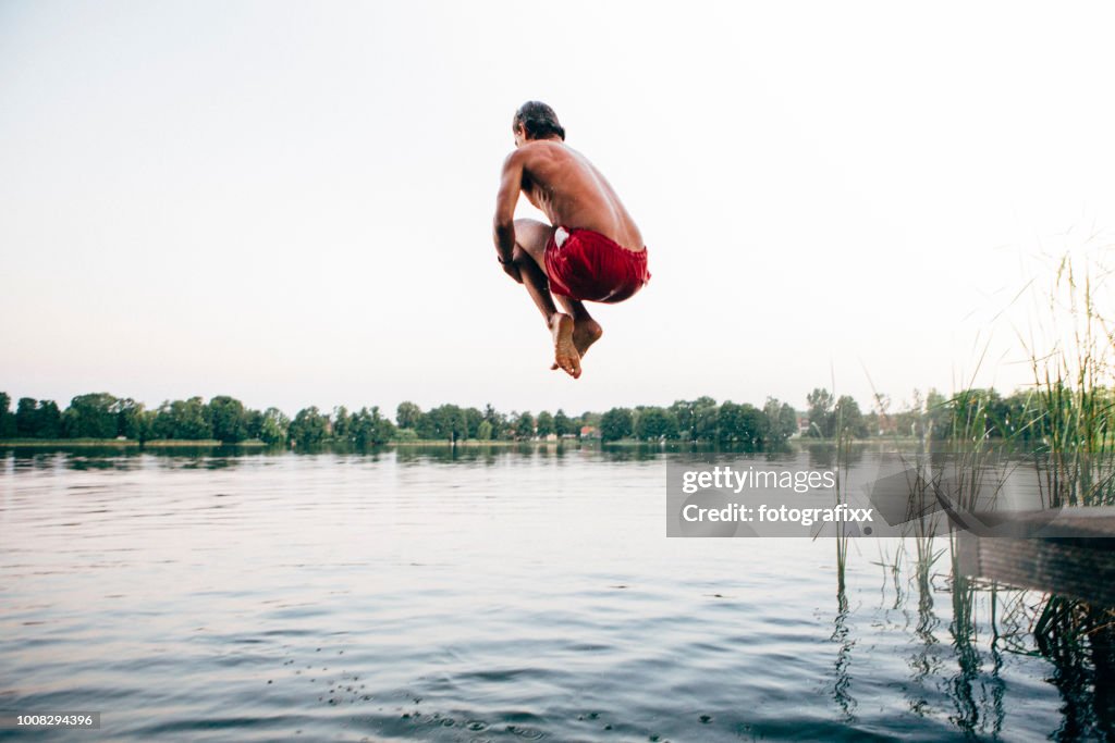 Cannonball: young man jumps into a lake