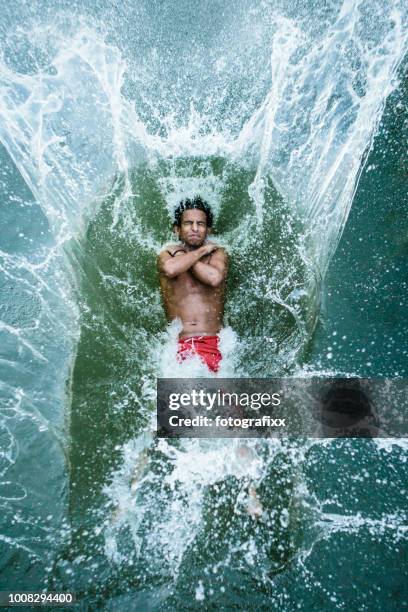 young man jumps backwards into a lake, water splashes around - leaning back stock pictures, royalty-free photos & images