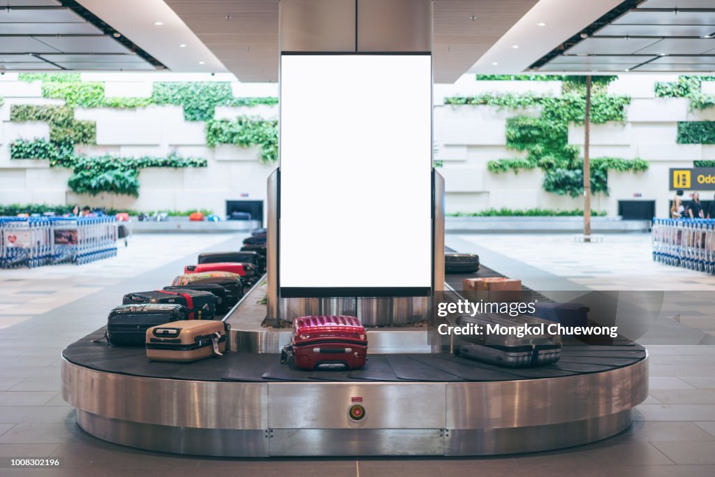 Blank advertising billboard with baggage and luggage in the international airport
