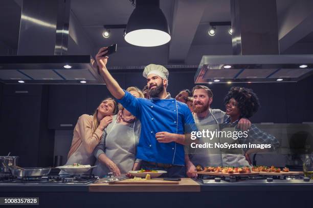 attendees of cooking class taking selfies with chef - chef competition stock pictures, royalty-free photos & images