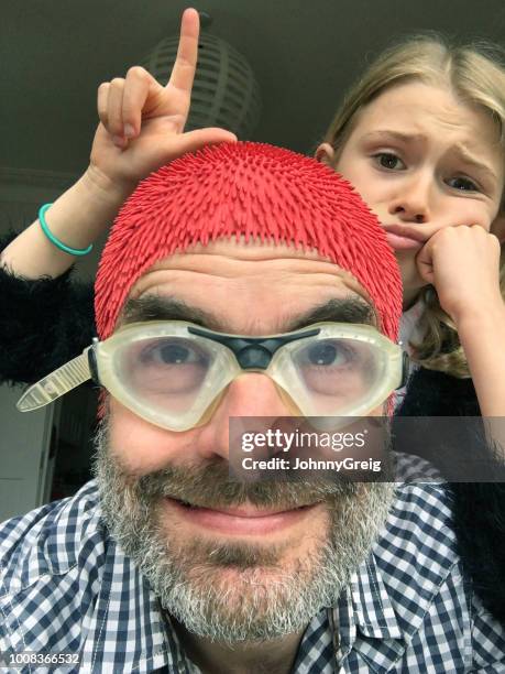 loser dad selfie - unimpressed photobomber daugther makes an l sign at father - naughty daughter stock pictures, royalty-free photos & images