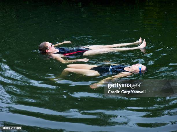 two women floating on water in a river - lea foto e immagini stock