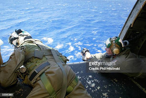 Helicopter crew chief Randall Elkins monitors a landing aboard the USS Lake Erie during the RIMPAC excercise operations July 11, 2002 near Oahu,...