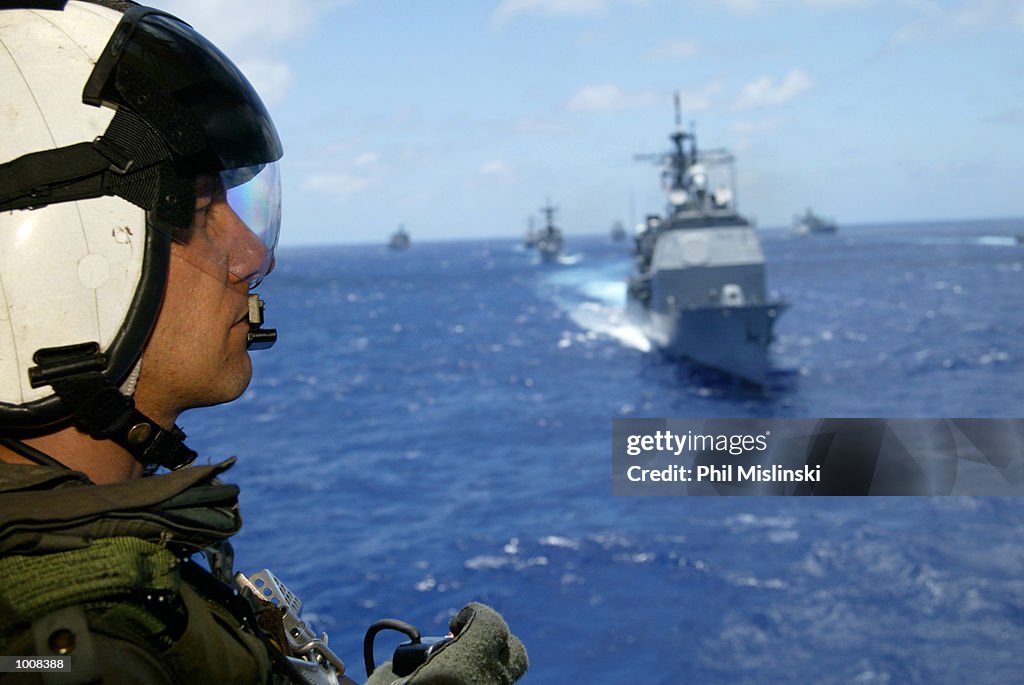 Operation Rimpac UH-3H helicopter crew chief Randall Elkins observes naval ships from ...