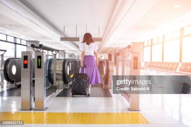 junge frau, die zu fuß in flughafen - narita international airport stock-fotos und bilder