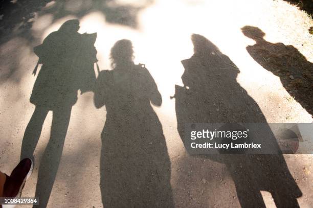 shadow of four women on a sunny day - journey pov stock pictures, royalty-free photos & images