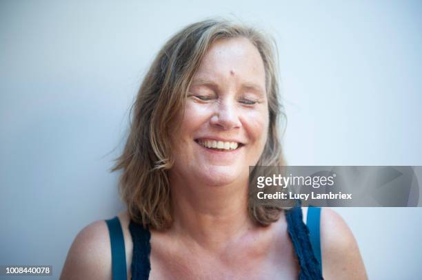 portrait of a mature woman laughing - introvert stock pictures, royalty-free photos & images
