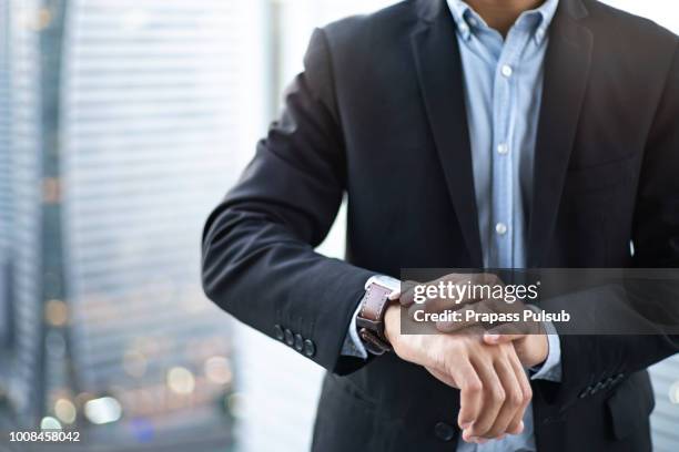 closeup designer watch on businessman hand, he looks on the time and hurrying - gold meets golden fotografías e imágenes de stock