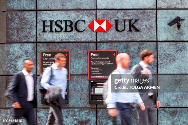Pedestrians walk past a HSBC UK bank branch in central London on July 31, 2018. - HSBC will publish their half-year results on August 6.