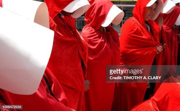 Women dressed as characters from the novel-turned-TV series "The Handmaid's Tale" protest in front of the Alexander Hamilton Customs House on July 31...