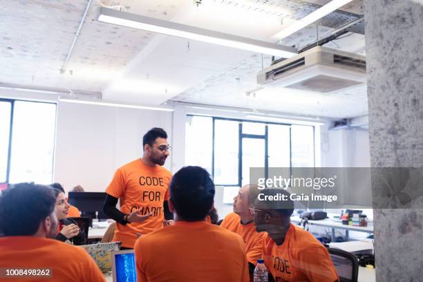 Hacker leading discussion, coding for charity at hackathon