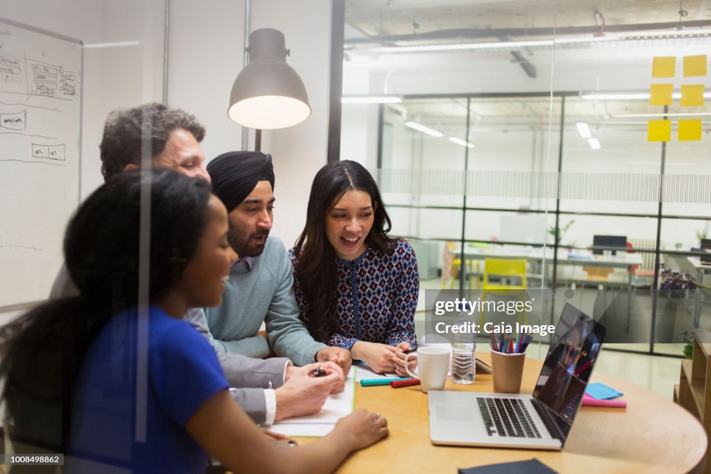 Creative business people video conferencing at laptop in conference room