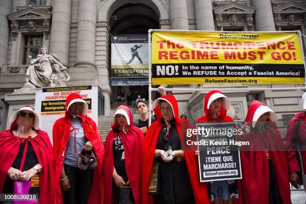 Activists dressed in the red garb of "The Handmaid's Tale" protest the Trump administration's immigration policies outside of the Department of...