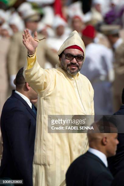 Moroccan King Mohammed VI greets the crowd as he stands in a limousine during a ceremony of allegiance, at the King's palace in Tetouan, on July 31...