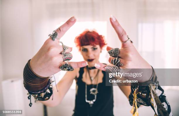 metal chica mostrando el gesto de cuernos de diablo - heavy fotografías e imágenes de stock