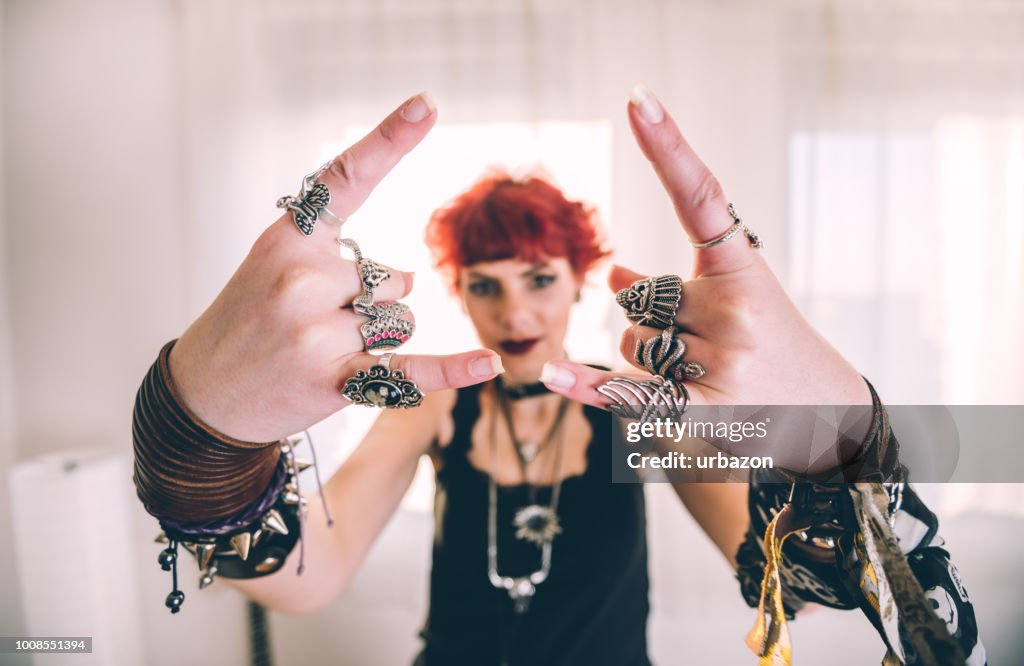 Metalen meisje tonen duivel hoorns gebaar