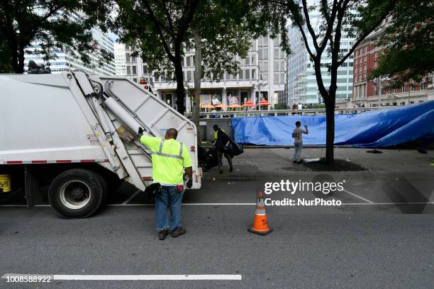 After the city issued an eviction notice Sanitation department workers clean up remainders of what started as an Abolish ICE protest camp, near City...