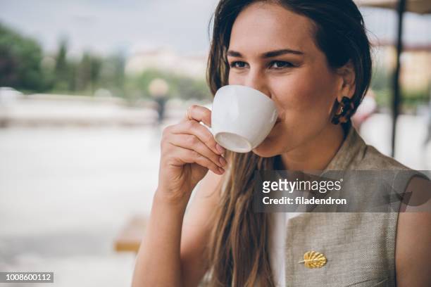 frau trinkt kaffee im freien - brooch stock-fotos und bilder