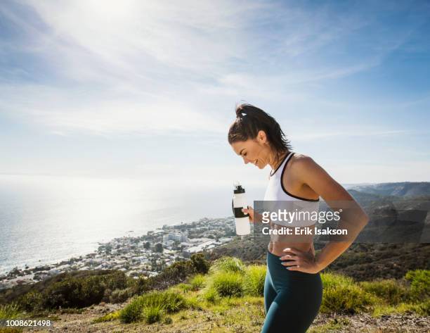 woman in sportswear with water bottle - laguna beach californië stockfoto's en -beelden