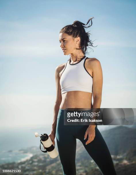 woman in sportswear with water bottle - naveltruitje stockfoto's en -beelden