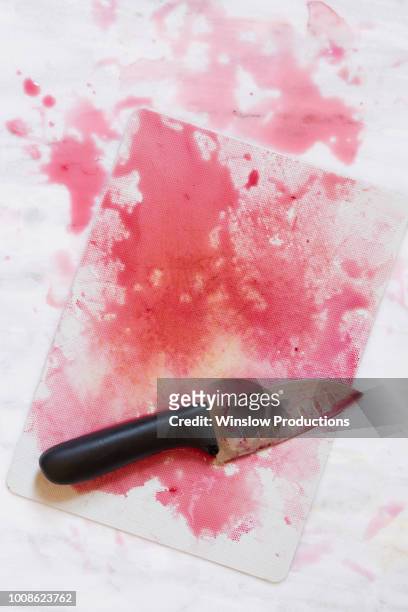 kitchen knife on chopping board with red juice - beetroot juice stockfoto's en -beelden