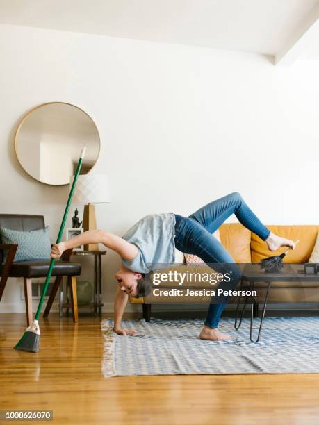 woman bending over backwards sweeping and dusting - contortionist stock pictures, royalty-free photos & images