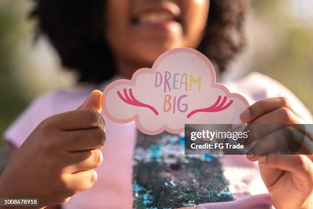 little cute girl showing paper: dream big - needs improvement stock pictures, royalty-free photos & images