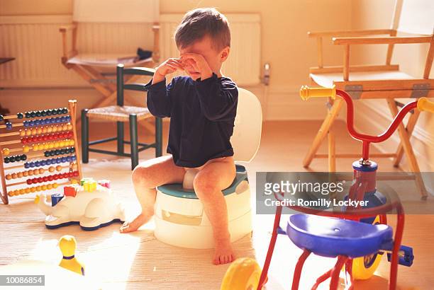 unhappy boy on the potty - child urinating stockfoto's en -beelden