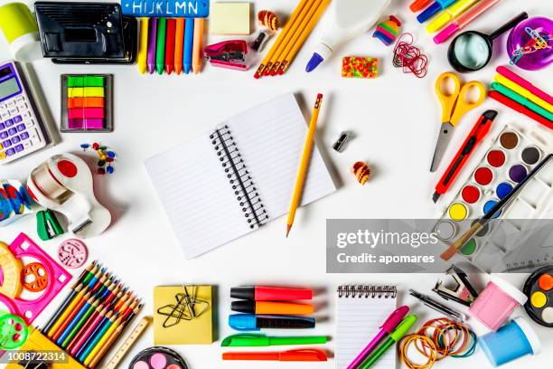 overhead shot of back to school office supplies on white background with paper note book into frame. - school supplies on table stock pictures, royalty-free photos & images