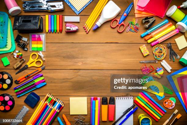 overhead shot of wood table with frame of school office supplies - school supplies stock pictures, royalty-free photos & images