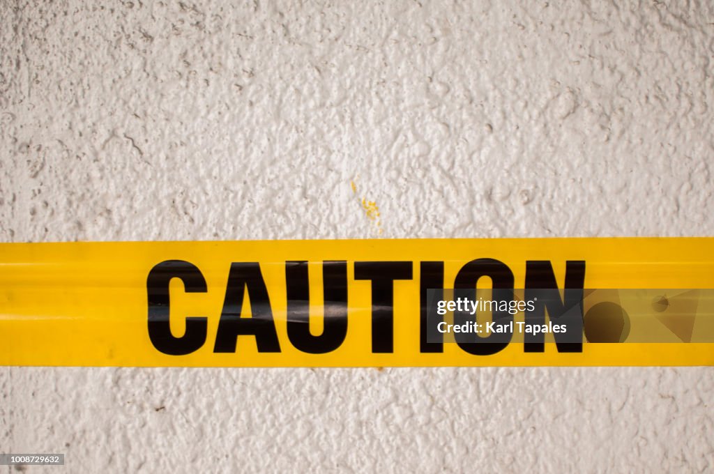 Yellow tape with caution sign