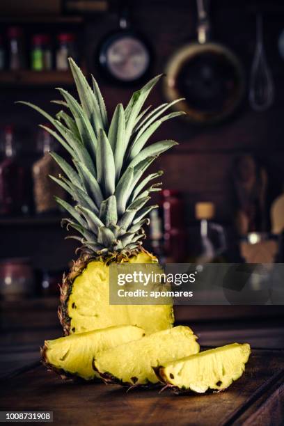 fresh tropical sliced pineapple on chopping board. natural lighting - pineapple halved stock pictures, royalty-free photos & images