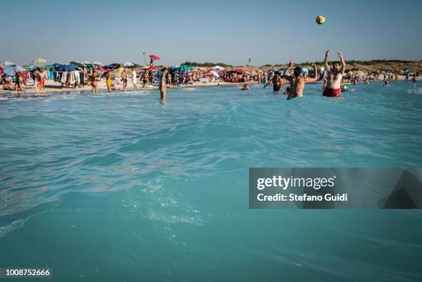 Young couple plays in the sea of Rosignano Marittima, the turquoise color of the water is due to years of discharges direct waste from the nearby...