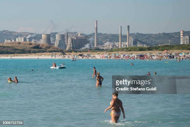 The Solvay factory dominates the post-apocalyptic background of the white beach, while the careless swimmers enjoy a typical summer day by the sea...