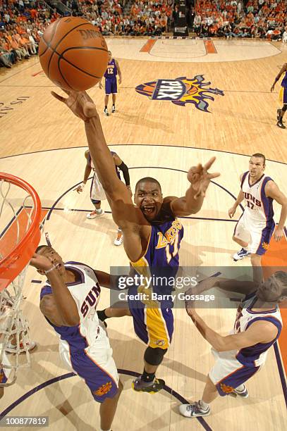 Andrew Bynum of the Los Angeles Lakers drives for a shot between Channing Frye and Goran Dragic of the Phoenix Suns in Game Four of the Western...