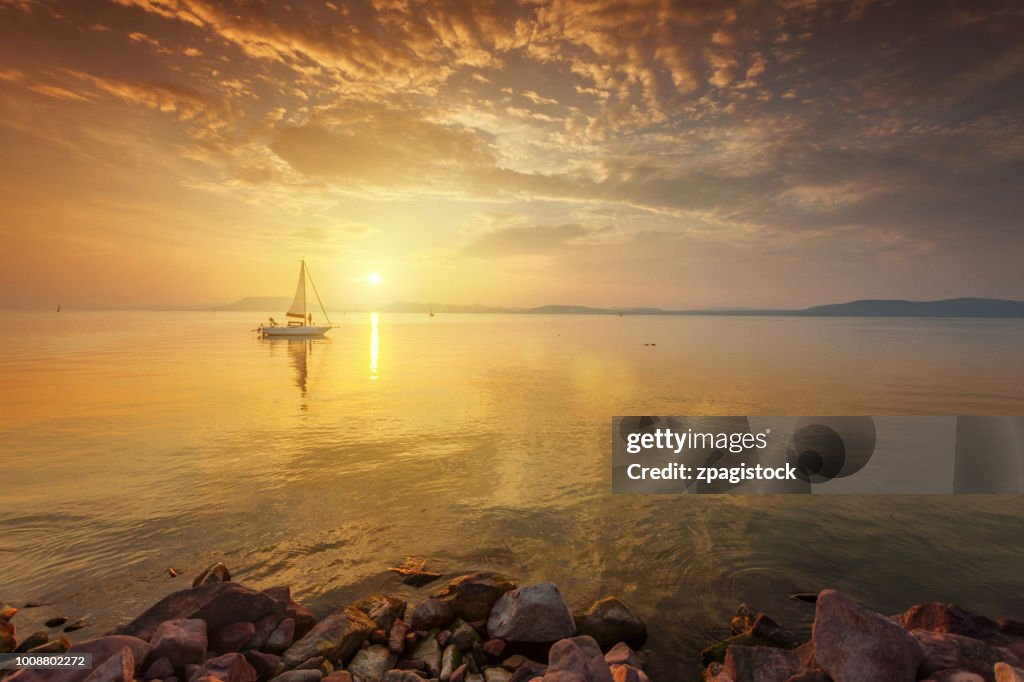 Sunset at the lake with a sailboat
