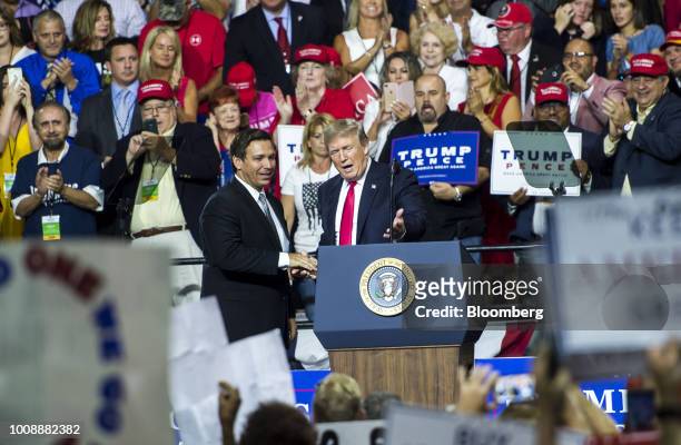 President Donald Trump, right, shakes hands with Representative Ron DeSantis, Republican candidate for governor of Florida, on stage during a rally...