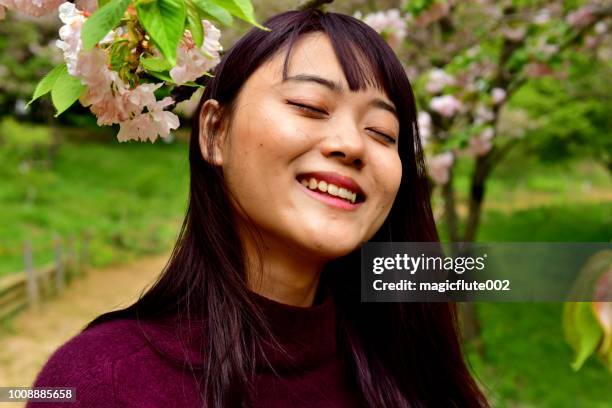 八王子の公園で桜の下で様々 な表情を作る若い日本女性 - 目を閉じた　女性 ストックフォトと画像