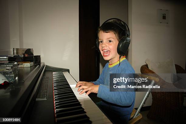 boy playing piano - young boy enjoying music stock-fotos und bilder