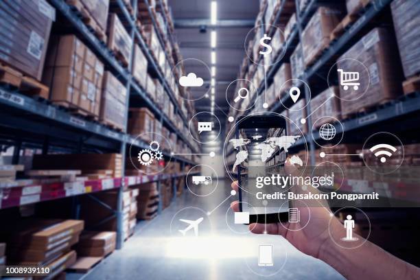 hand holding smartphone with ar application for check order pick time in smart factory warehouse, technology interface global partner connection for logistic import export background - category:internet stock-fotos und bilder